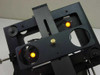 Close-up front view of custom optical stage assembly with both yellow LED indicator lights illuminated and powered on