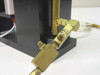 Close-up of brass pneumatic fittings and compression connectors on the base of the Daedal clamp assembly with clear tubing