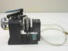 Daedal pneumatic clamp assembly left side view showing black anodized frame, blue lever, knurled wheel, and clear tubing with multi-pin cable