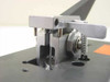 Close-up of wafer bonder lever pivot assembly showing spring, clamp bracket, and mounting hardware detail