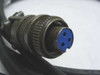 Close-up of 3-pin military circular connector end of Triad 201219-001 cable, showing threaded metal coupling nut and blue insert with three pin holes