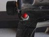 Close-up of red pushbutton switch and knurled adjustment knob on optical apparatus carriage