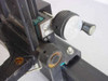 Close-up of lens carriage adjustment knobs and optical component mount on rail assembly