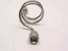 Close-up front view of SMA male connector end on stainless steel coiled semi-rigid coaxial cable showing gold center pin