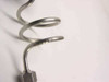 Close-up of coiled stainless steel semi-rigid coaxial cable body showing stamped part number marking on the tubing