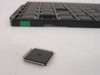 Motorola DSPE56009FJ81 DSP chip beside factory LQFP IC tray showing chip size and package