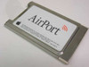 Apple AirPort 630-2883/C wireless PC Card — top view showing white AirPort label with Apple logo and orange WiFi symbol on silver metal PCMCIA housing