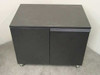 Savin Utility Cassette Storage Cabinet – front view showing two-door black laminate exterior and chrome ball casters