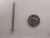 CF&I Steel 4D 1.5-inch common wire nail shown next to US penny for size reference