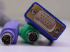 Close-up of KVM cable connector end showing VGA HD15 male (blue hood), green PS/2 mouse connector, and purple PS/2 keyboard connector