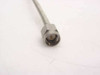 Close-up of straight SMA-male connector end of semi-rigid coax cable showing machined stainless body and center pin