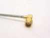 Close-up of SMA male right angle connector on semi-rigid coax cable — gold-plated brass body, 90-degree bend, braided silver outer jacket