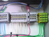 Bulk fill control panel terminal block array — DIN rail-mounted multi-position terminal blocks with yellow-green ground bus bar and multi-color wiring