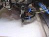 Punch nozzle tip detail – pneumatic punch head with blue push-in fittings making contact with white work surface