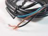 Efector KB-3020-BPKG proximity sensor — bare wire ends showing brown, blue, and black conductors with copper strands exposed