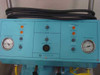 ML1000 control panel close-up showing Drain Tank and Supply Tank indicator lights, Power On/Off switch, Alert Hi/Low indicator, and dual analog pressure gauges on teal enclosure