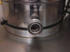 Close-up of stainless steel drain tank section showing DRAIN label and quick-disconnect drain port fitting
