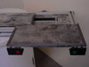 Alternate top view of moving table showing surface staining and red and green push-button switches on table ends