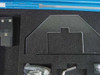 Close-up of foam insert upper section showing acrylic alignment template, hex key, and hardware bag in cutouts