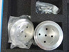 Two machined aluminum disc components with mounting holes, one wrapped in plastic, alongside a hardware bag