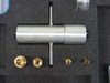 Stainless steel cylindrical T-handle tool and four brass fittings and adapters in foam cutouts