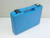 Exterior of blue hard plastic carry case with black latches and handle, closed