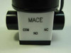 Mace solenoid valve bottom body close-up showing COM, NO, and NC port labels on white Teflon body