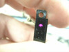 Omron EE-SB5 sensor held close-up showing illuminated IR LED emitter glowing pink/purple inside sensor cavity