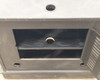Close-up of cabinet top surface showing central round cable/wire pass-through hole and upper interior shelf visible below