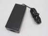 Toshiba PA7487U AC adapter — three-quarter top view showing ribbed black housing and attached barrel plug output cable coiled alongside
