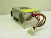 SourceTek IPS-135U 135W switching power supply – left side view showing rear AC inlet, ventilation grille, and multiple Molex output connectors with wiring harness