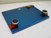 Air Safety dual hand safety switch — angled overhead view of blue anodized aluminum mounting plate with two red-bracket palm button assemblies and Clippard brass valve mounted at top
