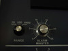 Close-up of front panel controls showing Range selector knob (10, 100, 1000) and Alarm Minutes adjustable dial (0–25 minutes)