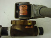 Close-up of Jack Evans solenoid valve coil showing label with Volts 120, Hz 50-60, Watts 9, Jack Evans Controls Madison WI USA, attached to brass valve body with Flow label