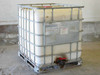 Trustor Coatings 6900 WearMax UV Colorless Floor Stain – full IBC tote in metal cage frame on pallet, front view with red ball valve outlet at base