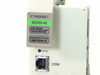 Cabletron 6E233-49 module faceplate close-up – AGI Ethernet label, part number 6E233-49, barcode, reset button, and RJ-45 COM port