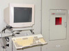 CMS PS-700 system — CRT monitor and keyboard on swing-arm mount with CMS Control Micro Systems laser cabinet door and viewport in background
