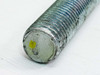 Close-up of galvanized all-thread rod end showing thread profile and small yellow identification mark on cut face