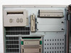 Digital AlphaServer 2100 interior close-up – wide tape or floppy drive at upper left, 3.5-inch floppy drive center, CD-ROM drive upper right, two SCSI drives with green tabs in lower bays