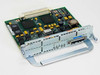 Cisco NM-1HSSI High Speed Serial Interface network module – angled top view showing PCB with two large controller ICs, yellow capacitors, and front faceplate with HSSI port