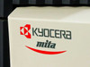 Kyocera Mita logo close-up – red Kyocera diamond logo and 'mita' script on printer body