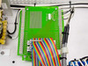 Interior view of Keithley 61300 enclosure showing green relay board 62200 with ribbon cable and wiring harness