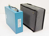 Rear view of TPI 108-DS1 blue module and gray TPI carry case showing side profiles and overall form factor