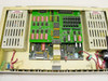 STS D61486-01 interior view with top cover removed showing main PCB assembly with ICs, relay bank, ribbon cable, and dual power supply modules with high-voltage warning labels