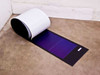 Uni-Solar PVL-144 144W amorphous flexible solar panel partially unrolled showing full laminate length and white backing — floor view