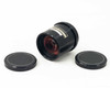 General Electric GS-028 projector lens shown on its side with both front and rear lens caps removed, revealing red-coated glass elements
