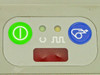 Zebra Cameo 2 front panel close-up showing green power button, two status indicator LEDs (battery and media), red paper-out indicator window, and blue paper feed button
