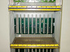 Rolm 9200 PBX chassis – middle shelf bay detail showing empty card slots with green boards partially populated and yellow connector rail