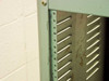 Close-up of green rackmount chassis corner showing rail strip, mounting holes, and surface rust on vented side panel