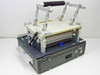 Circuit Check TF12000 Thermopile Laminator and Cutter — rear-right three-quarter view showing articulated laminator arm raised and blue connector fixture on platen